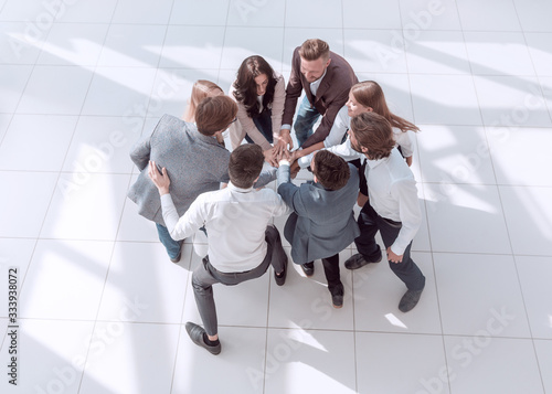 top view. successful business team standing in a circle with hands up.