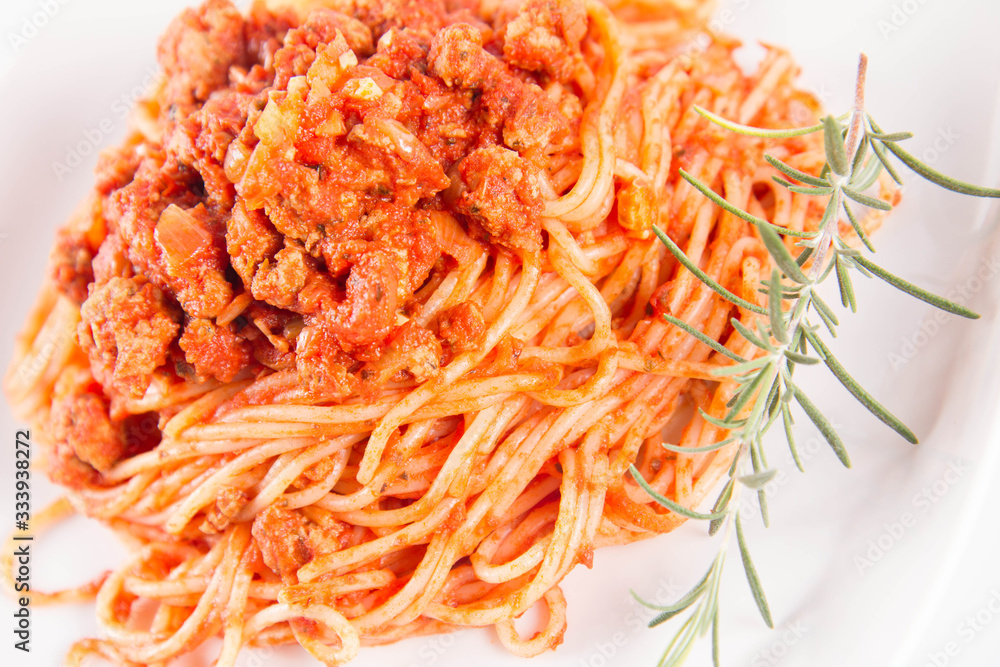 Spaghetti bolognese on a plate decorated with a rosemary twig Spaghetti bolognese on a plate decorated with a rosemary twig