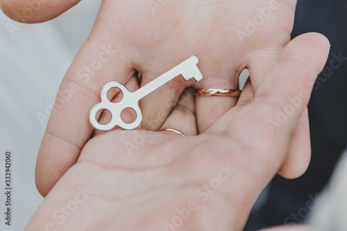 Groom and bride holding lock key in their hands