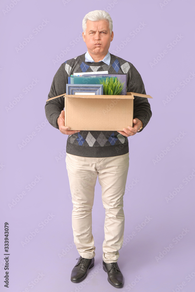 Sad fired mature man with personal stuff on color background Sad fired mature man with personal stuff on color background