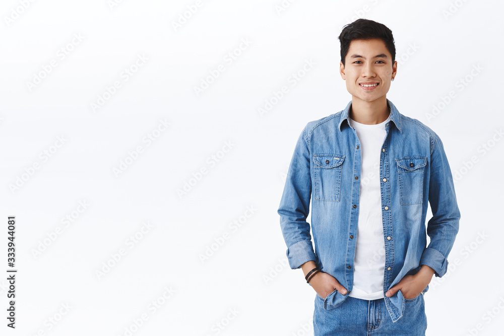 Youth, career, headhunter and lifestyle concept. Portrait of smiling young healthy asian guy smiling, hold hands in pockets casually standing over white background, pleased making good investment Youth, career, headhunter and lifestyle concept. Portrait of smiling young healthy asian guy smiling, hold hands in pockets casually standing over white background, pleased making good investment
