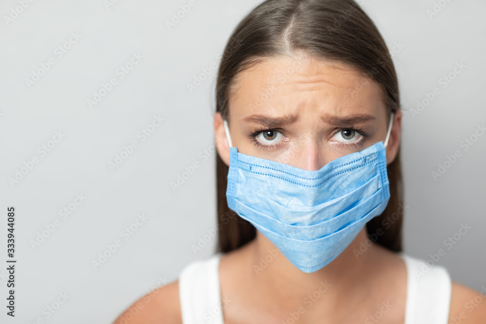 Unhappy Girl Wearing Mask During Pandemic Posing Over White Background Unhappy Girl Wearing Mask During Pandemic Posing Over White Background