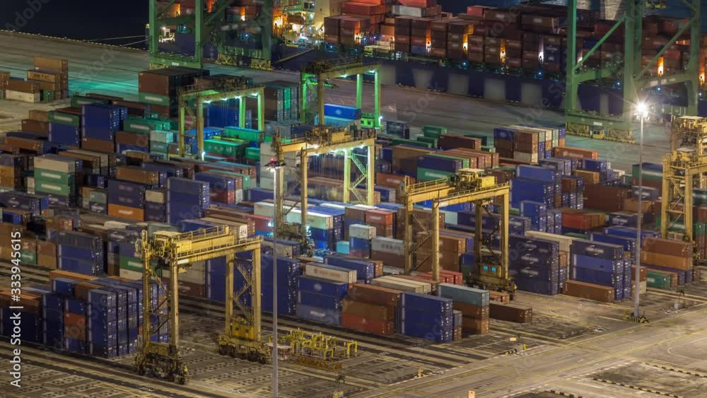 Commercial port of Singapore night timelapse. Close up view of busiest Asian cargo port with hundreds of loaders moving export and import goods and thousands of containers in harbor Commercial port of Singapore night timelapse. Close up view of busiest Asian cargo port with hundreds of loaders moving export and import goods and thousands of containers in harbor