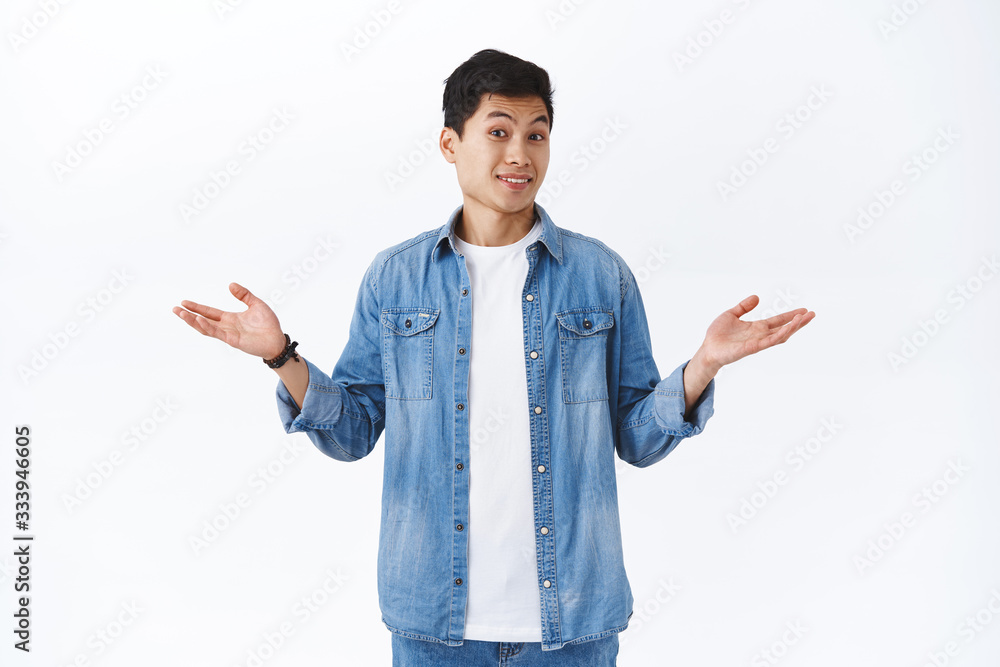 Portrait of clueless handsome asian young man cant answer, have no idea, shrugging and spread hands sideways unaware, acting puzzled as avoiding answering question, white background Portrait of clueless handsome asian young man cant answer, have no idea, shrugging and spread hands sideways unaware, acting puzzled as avoiding answering question, white background