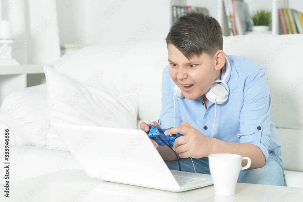 Portrait of boy playing computer game with laptop Portrait of boy playing computer game with laptop