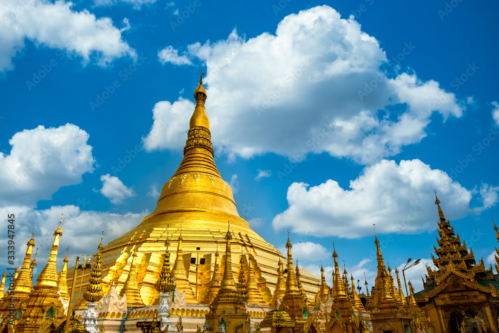 Naklejka premium Pagoda Shwedagon atrakcją w Yagon City na niebieskim tle nieba, starożytna architektura pagody Shwedagon to piękna pagoda w Azji Południowo-Wschodniej, Rangun, Birmie, Azji, Azji.