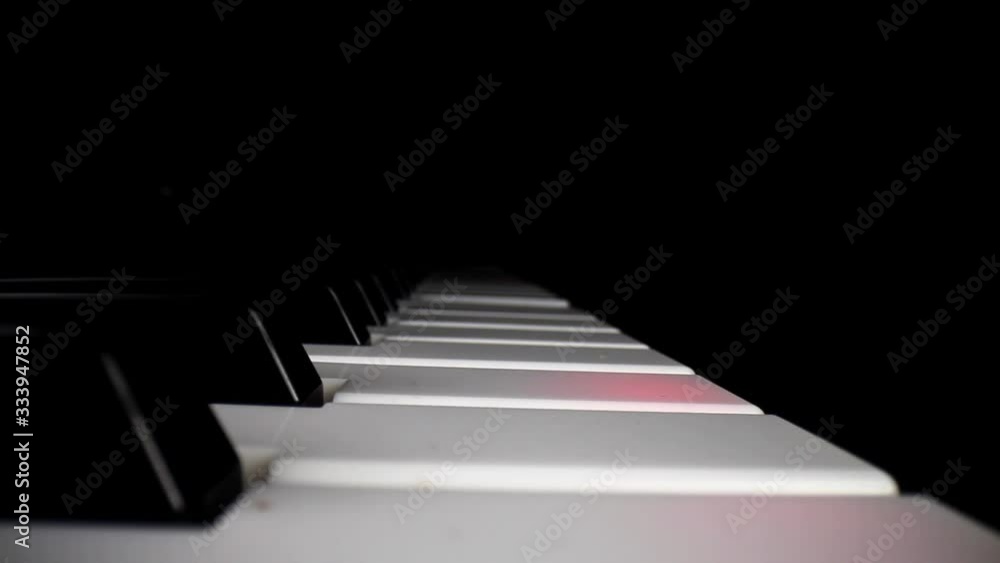 Wide angle macro of electronic keyboard - static shot of keyboard and the song assist lighting the keys a red color, movement down and then pulling away from keys as song continues to play. Wide angle macro of electronic keyboard - static shot of keyboard and the song assist lighting the keys a red color, movement down and then pulling away from keys as song continues to play.