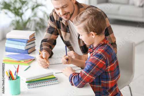 Father helping his little s...