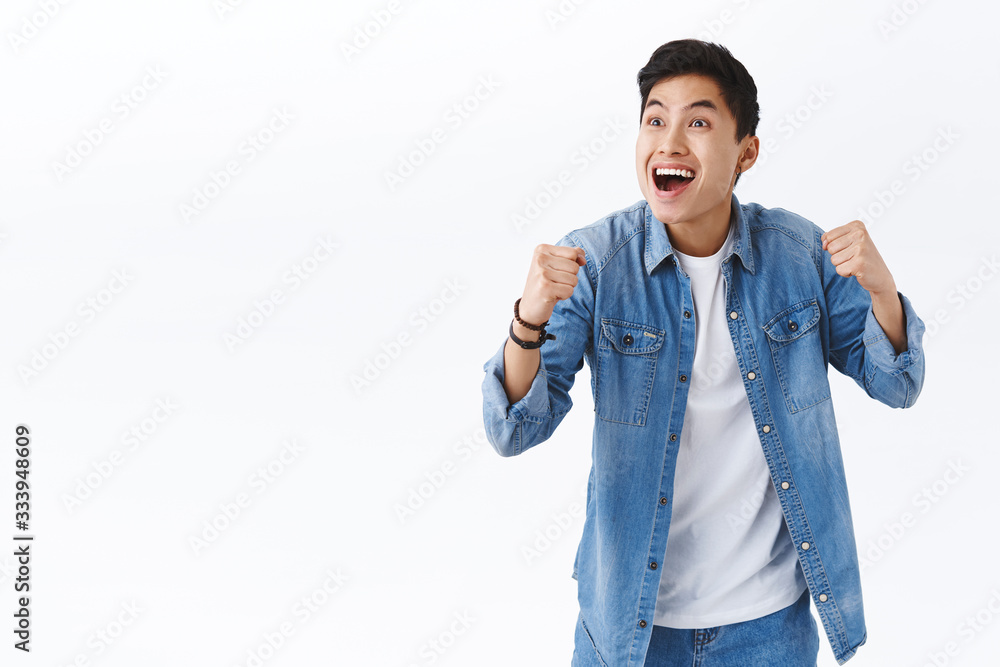 Portrait of happy energized young excited asian man watching sports game on tv in pub, cheering for team scored goal, smiling pleased, clench fists in victory, success gesture, triumphing Portrait of happy energized young excited asian man watching sports game on tv in pub, cheering for team scored goal, smiling pleased, clench fists in victory, success gesture, triumphing