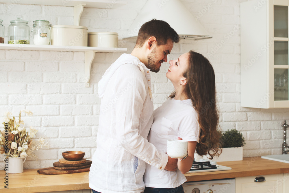 Lifestyle consept at home with couple young men and woman with cup of coffee or tea in kitchen Lifestyle consept at home with couple young men and woman with cup of coffee or tea in kitchen