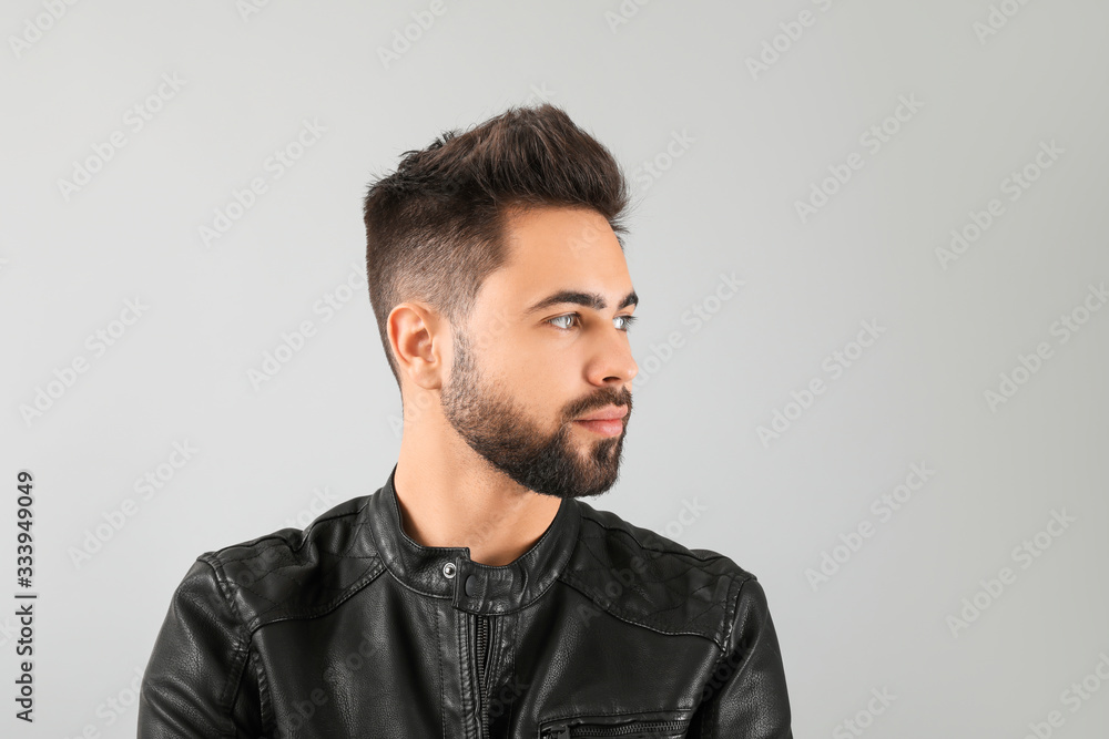 Handsome man with healthy hair on light background