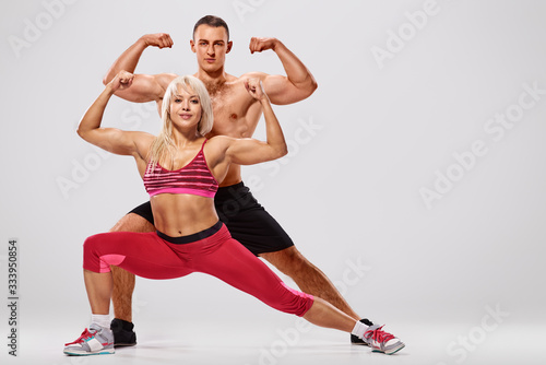 Young sporty couple bodybuilders training together and showing biceps