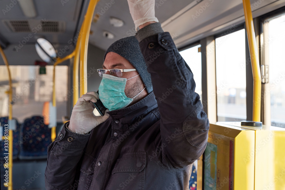 Man in face mask and protective gloves in the bus in public transport while coronavirus and pandemic. Life and business while covid19. Man in face mask and protective gloves in the bus in public transport while coronavirus and pandemic. Life and business while covid19.