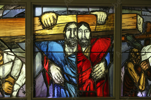 Fotografiet Simon of Cyrene carries the cross, stained glass window by Sieger Koder in Chape