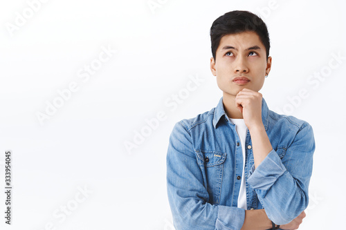 Fotografie Portrait of thoughtful smart asian man thinking, male student solving puzzled, l