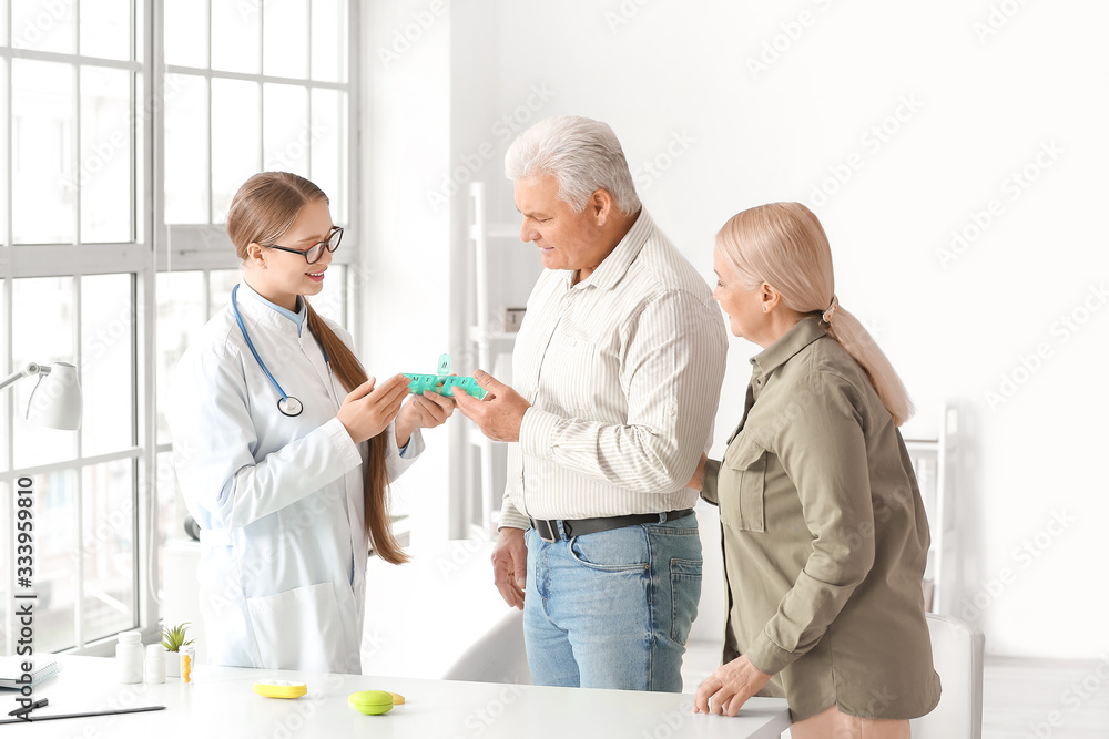Doctor giving pills to senior couple in clinic Doctor giving pills to senior couple in clinic