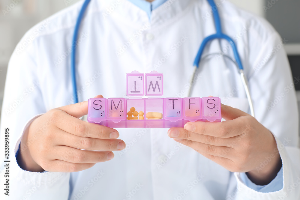 Female doctor with pills box in clinic, closeup Female doctor with pills box in clinic, closeup