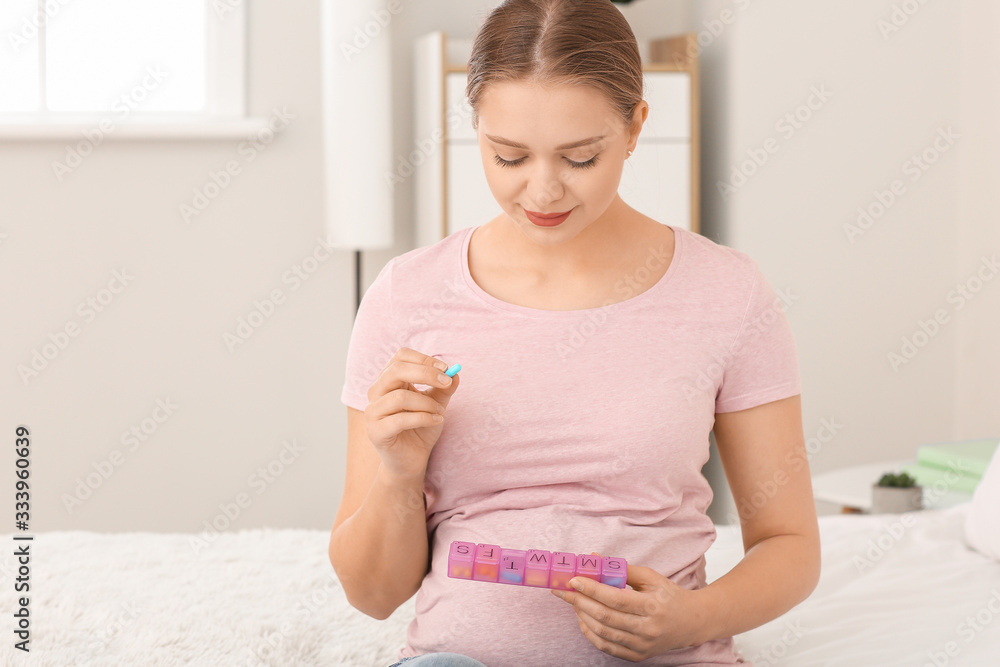 Young pregnant woman with pills box at home Young pregnant woman with pills box at home