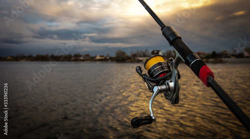 Fishing reel and rod, blurred background.