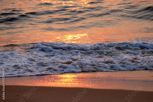 Wave rolling over the sands on Candolim Beach, North Goa, India photo