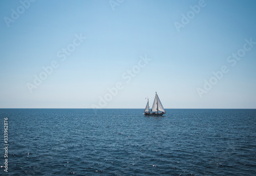 Segelboot Zweismaster weiss segelt auf offenem Meer unter blauem Himmel
