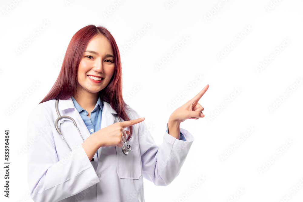 Young asian female doctor pointing finger to copy space. smiley face, happy. Medical woman doctor wear coats, stethoscope around neck. Young woman doctor professional medical care, health care concept Young asian female doctor pointing finger to copy space. smiley face, happy. Medical woman doctor wear coats, stethoscope around neck. Young woman doctor professional medical care, health care concept