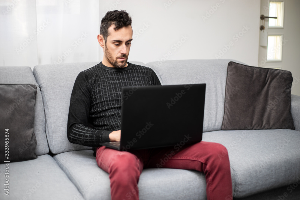 Man working on his laptop pc at home Man working on his laptop pc at home