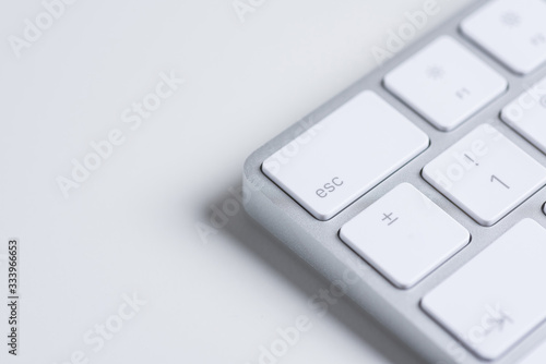 Computers. White minimalistic aluminium keyboard on a white table. Closeup