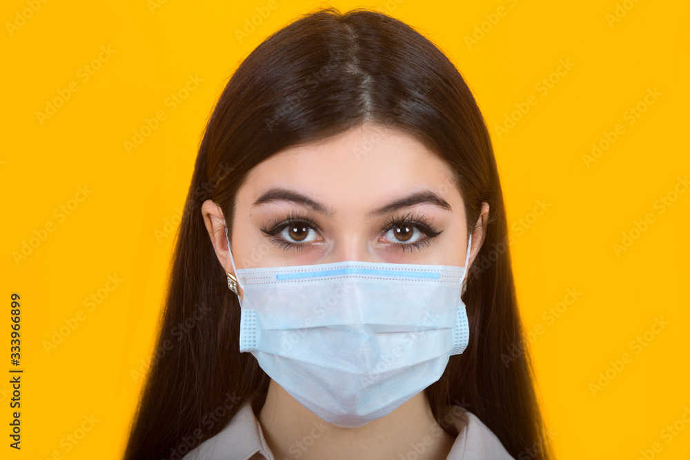 beautiful young woman in medical mask on a yellow background beautiful young woman in medical mask on a yellow background