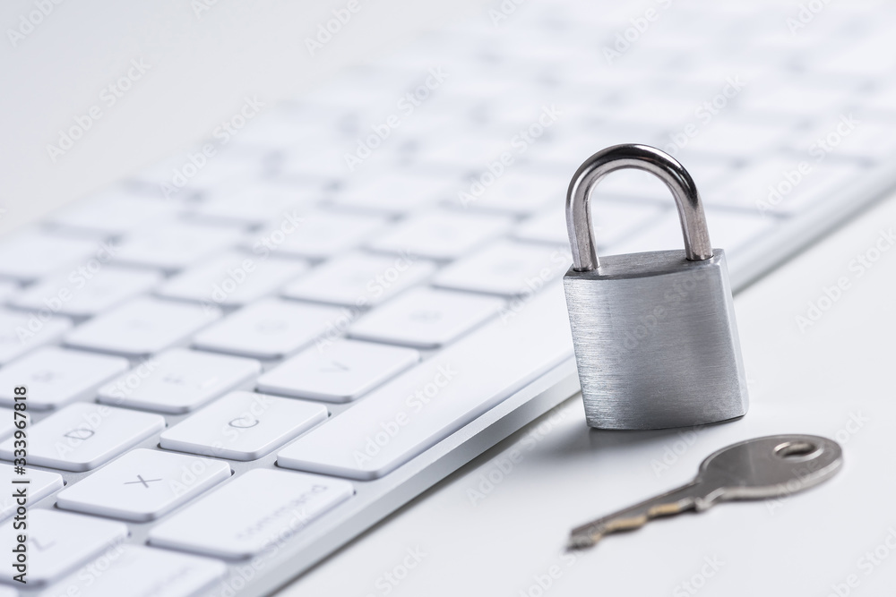 Data safety. Steel lock and key next to a white minimalistic keyboard Data safety. Steel lock and key next to a white minimalistic keyboard