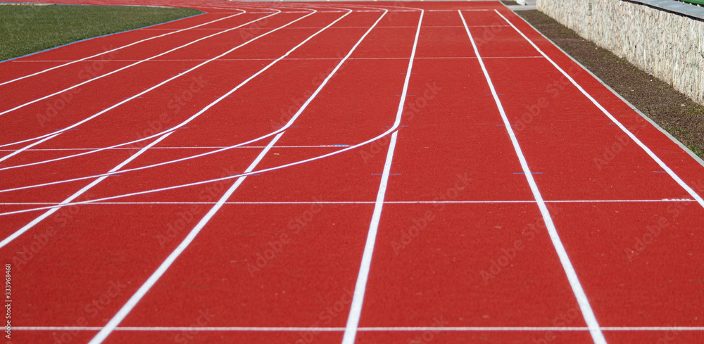 Run race track in sport stadium. Detail of a red running sports segment. Sport background