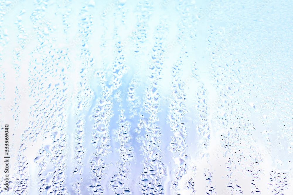 Moisture drops and water lanes on glass. Blue sky close up background Moisture drops and water lanes on glass. Blue sky close up background