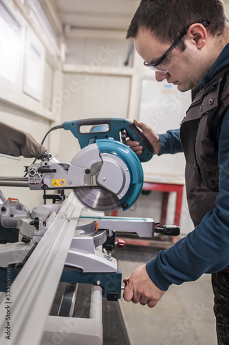 Worker technician works with electric wheel grinding on steel structure