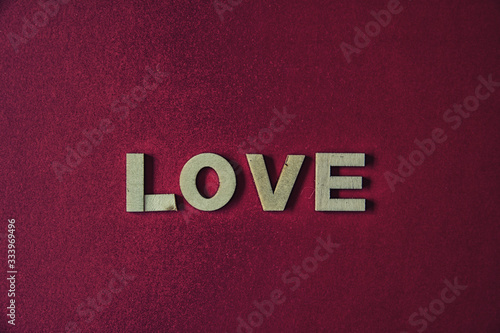 Red background with the word love with wooden letters