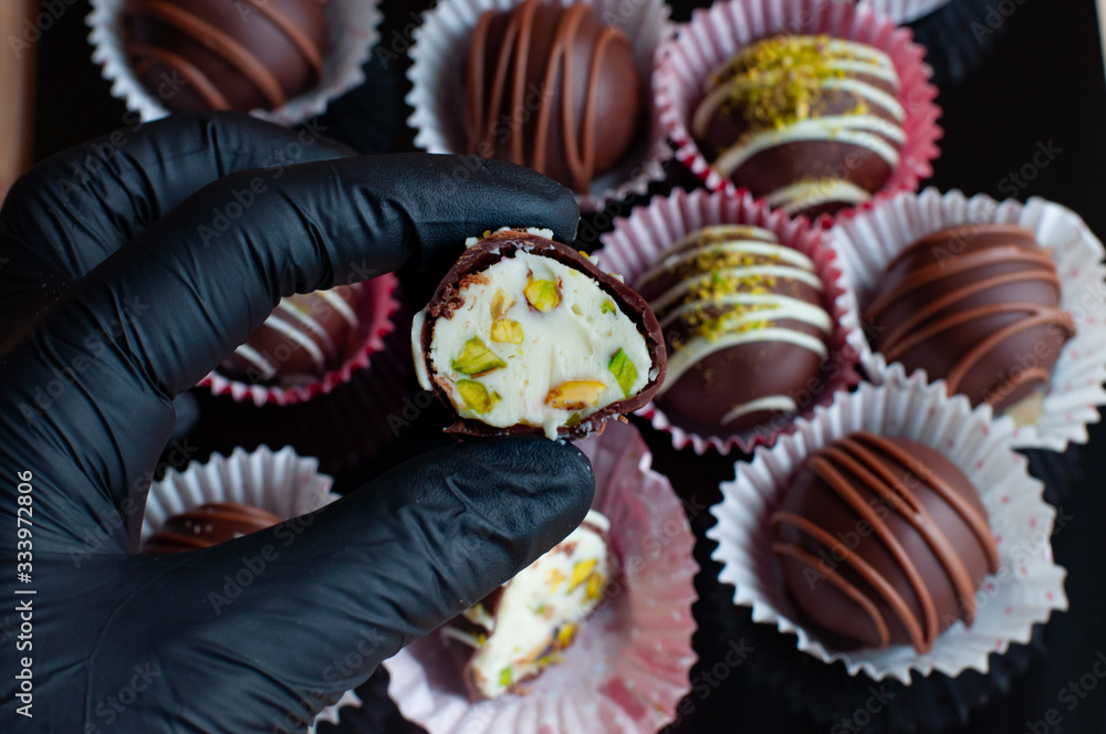 Hand in gloves shows what is inside chocolate candies Hand in gloves shows what is inside chocolate candies