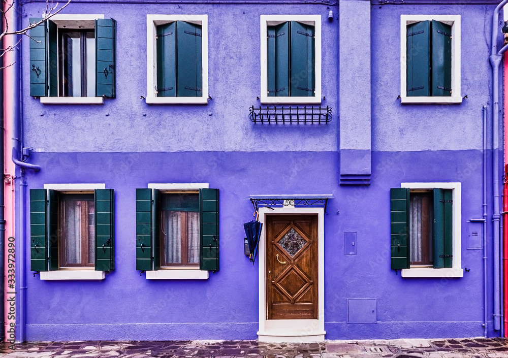 Facade of a violet house with small windows, located in Burano (Italy). Colorful house. Facade of a violet house with small windows, located in Burano (Italy). Colorful house.