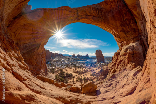 Famous Arches Park in Utah winter morning with a sunburst
