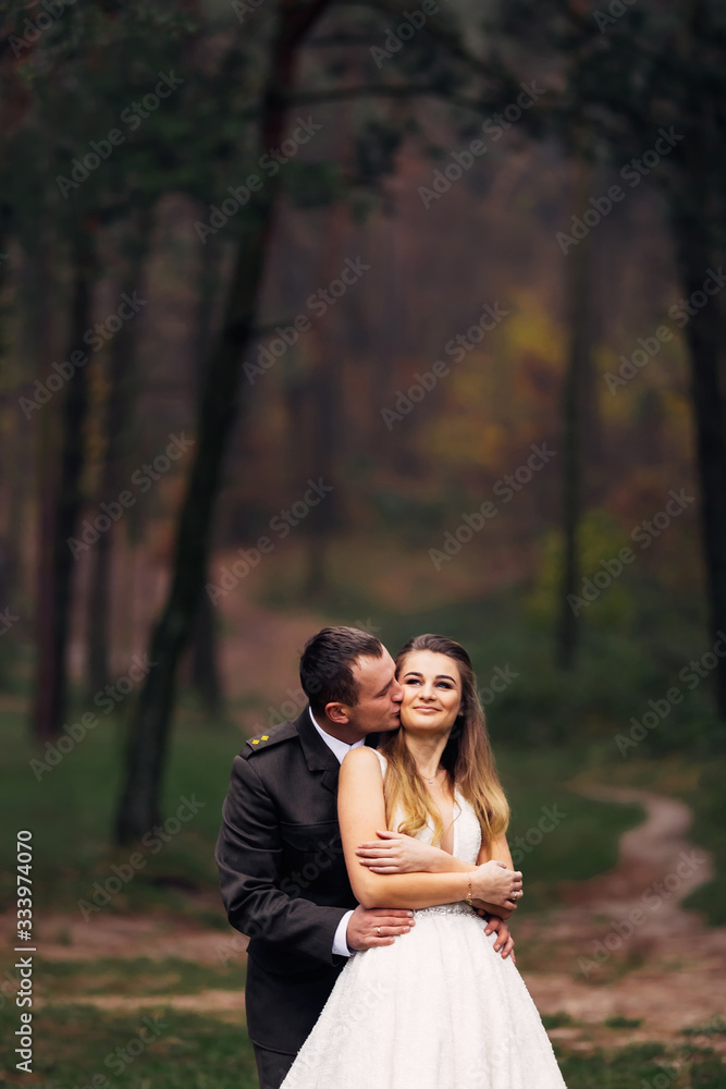 the groom in military uniform hugs the bride and they smile. new the groom in military uniform hugs the bride and they smile. new