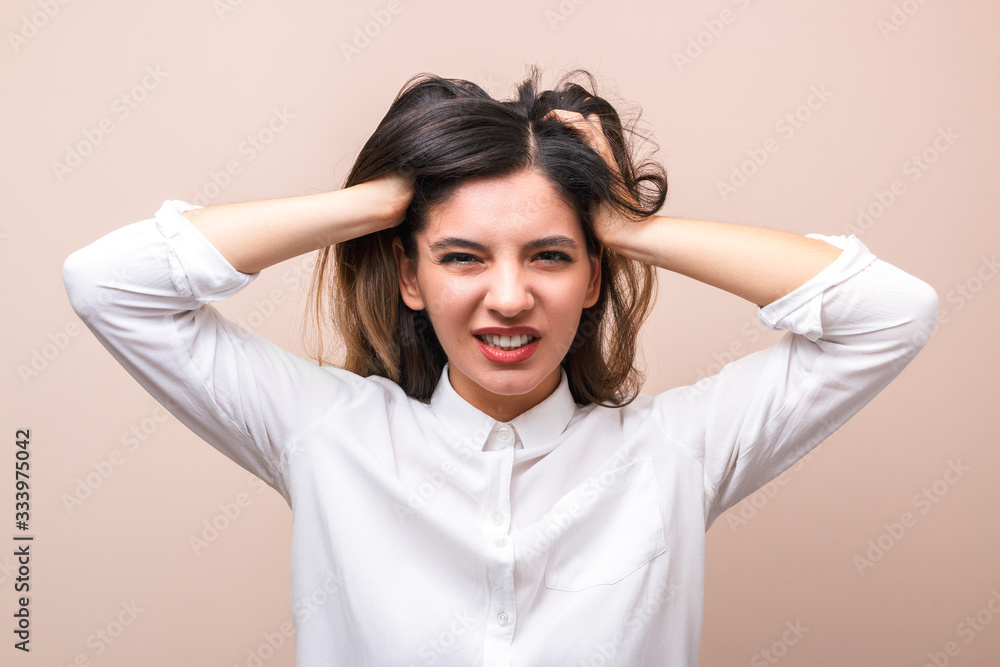 news influence. portrait of young annoyed businesswoman in white shirt with collar pulling her hairs and getting crazy news influence. portrait of young annoyed businesswoman in white shirt with collar pulling her hairs and getting crazy