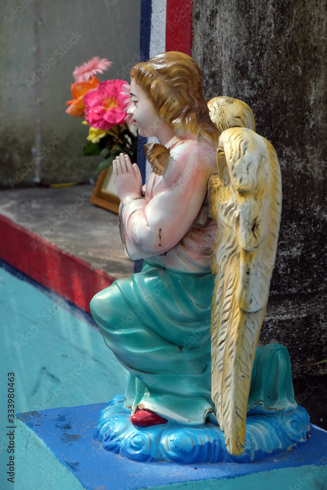 Fototapeta premium Angel at the Tomb of the Croatian Jesuit Missionary Ante Gabric Behind the Catholic Church in Kumrokhali, West Bengal, India