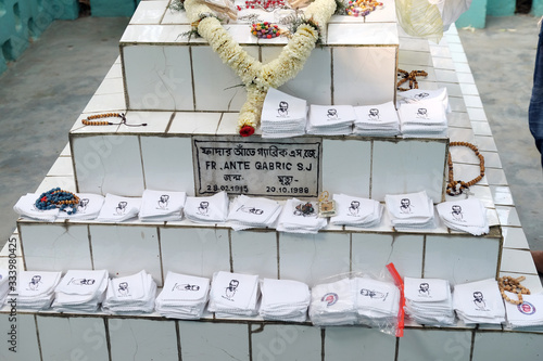 Religious objects are waiting for a blessing on the grave of Croatian missionaries, Jesuit father Ante Gabric in Kumrokhali, West Bengal, India photo