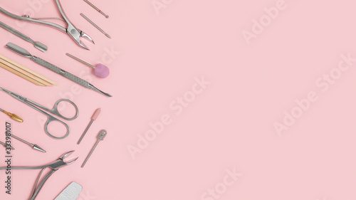 Nail care accessories. Professional steel pedicure tools. Manicure scissors, pusher, tongs, cutter, clipper and nozzles for polishing nails isolated on a pink background. Beauty concept. © Vitaliy Scherbonos