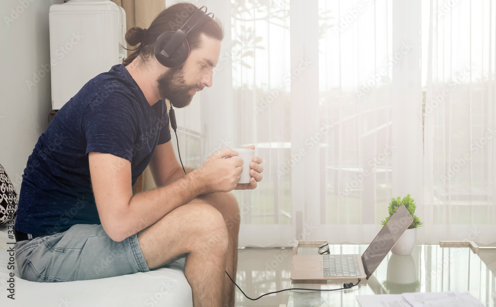 A man works from home using a laptop on the Internet. Freelancer. Work at a distance. Programmer. Quarantine A man works from home using a laptop on the Internet. Freelancer. Work at a distance. Programmer. Quarantine