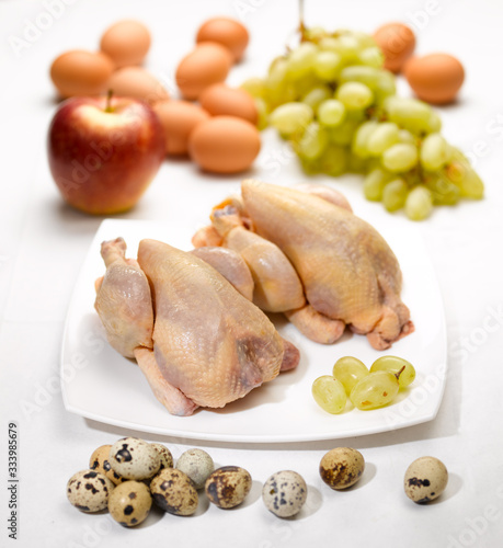 raw chicken eggs and fruits on the kitchen table