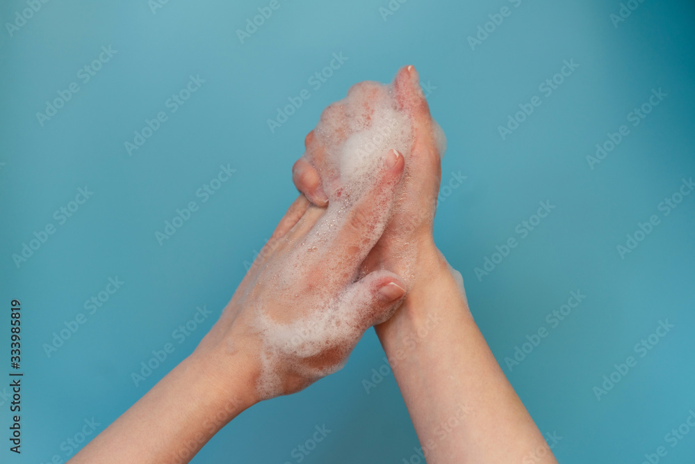 Woman use soap and washing hands isolated on blue background. Woman use soap and washing hands isolated on blue background.