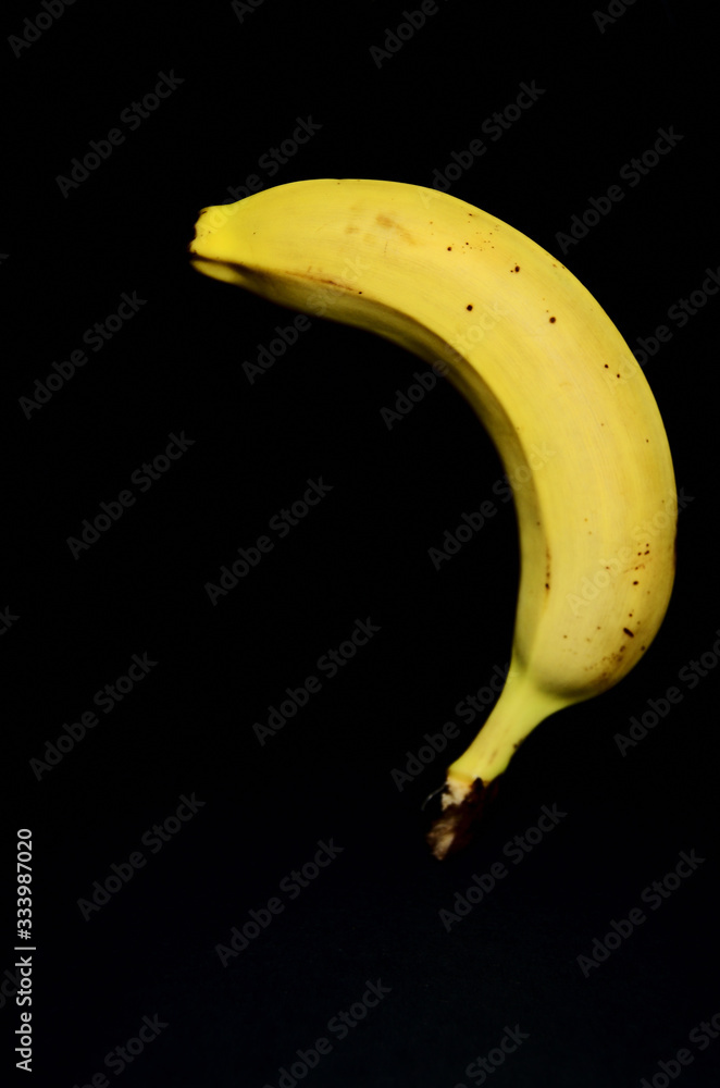 one yellow banana on a black background upside down with copy space one yellow banana on a black background upside down with copy space