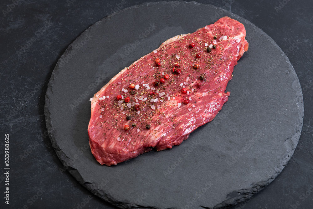 Raw fresh marbled meat and seasonings on dark background top view Raw fresh marbled meat and seasonings on dark background top view