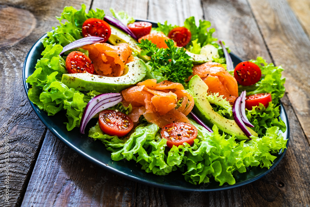 Salmon salad - smoked salmon and vegetables on wooden background Salmon salad - smoked salmon and vegetables on wooden background