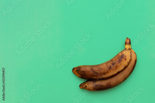 Ripe banana on a green background. Harvest 2020, fruits, flat lay, copy space, coronavirus, covid-19.