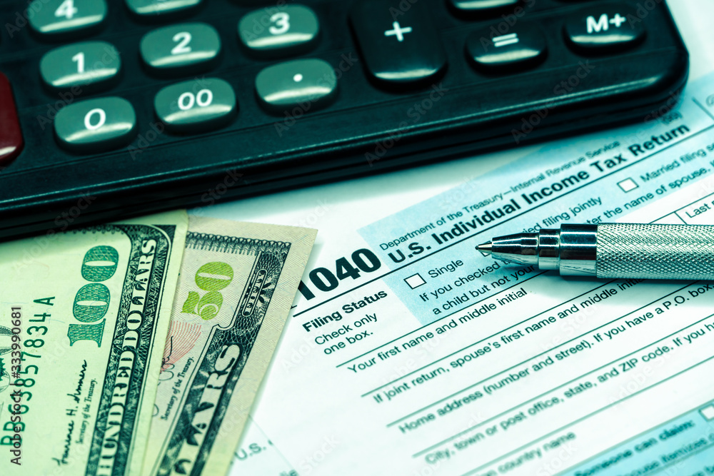 US tax form 1040 with pen and calculator. tax form law document usa US tax form 1040 with pen and calculator. tax form law document usa